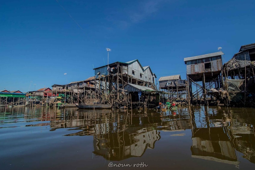 A floating village with wooden houses and boats. 1
