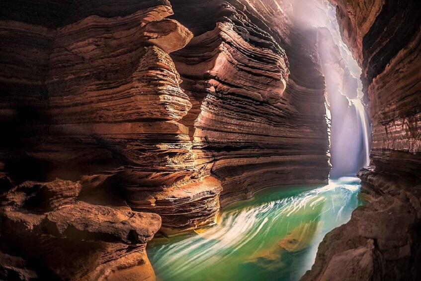 Un canyon con formazioni rocciose stratificate e un fiume che scorre. 1