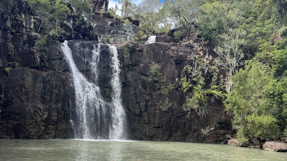 A waterfall cascading down a rocky cliff into a body of water. 2