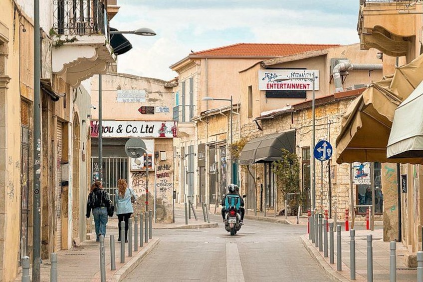 Una calle con edificios, una motocicleta y peatones. 2