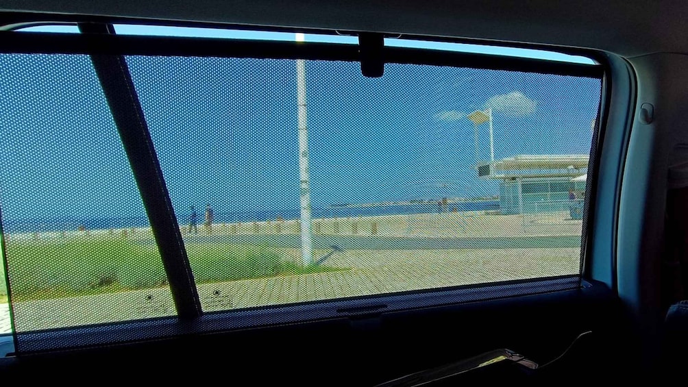 Ventana de un vehículo mostrando un cielo despejado y un paisaje lejano. 3