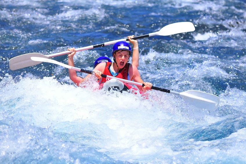 Une personne fait du kayak avec une pagaie blanche sur une étendue d'eau. 5