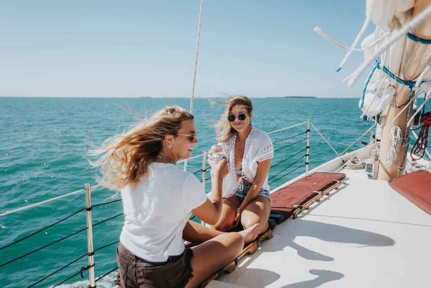 Two people on a boat, one holding a camera, with the sea and a distant island in the background. 5