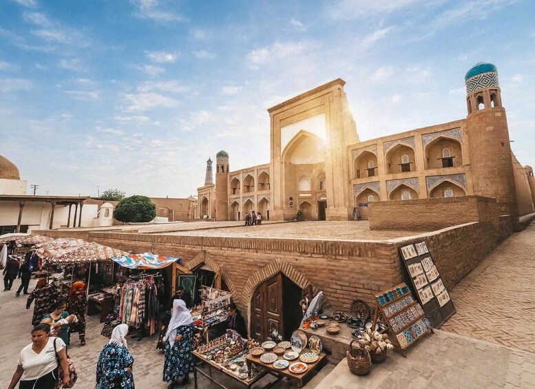 Un bâtiment historique doté d’arcades et d’un dôme, entouré d’un marché animé où l’on trouve des étals et beaucoup de monde. 5