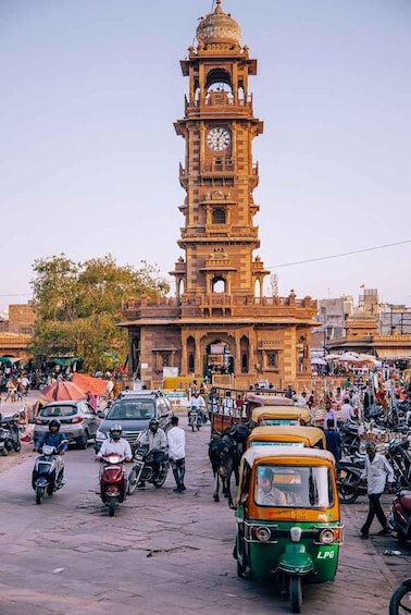 A busy street with a prominent clock tower in the background. 5