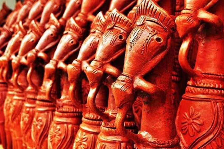 A row of intricately carved wooden figures, likely representing mythological or cultural themes. 1