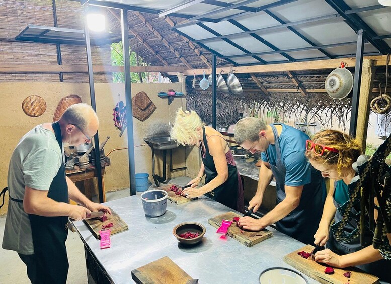 A group of people engaged in a cooking activity in a rustic kitchen setting. 3