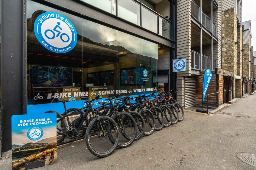 A bike rental shop with bicycles parked outside and a sign advertising bike hire and ride packages. 2