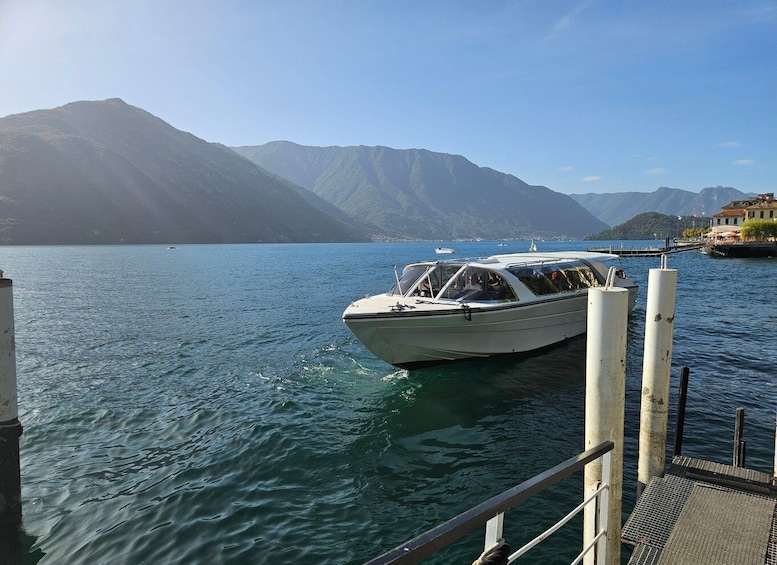 A boat docked at a pier with mountains in the background. 1