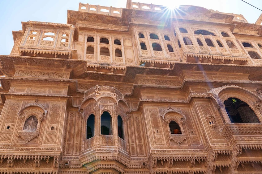 A multi-tiered, intricately carved building with arched windows and balconies. 5