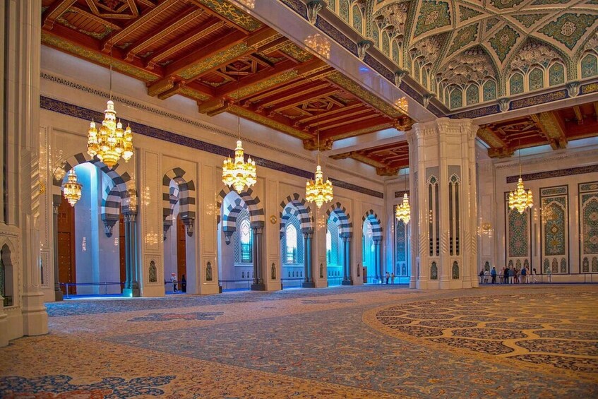An ornate interior with high ceilings, chandeliers, and intricate wall designs. 3