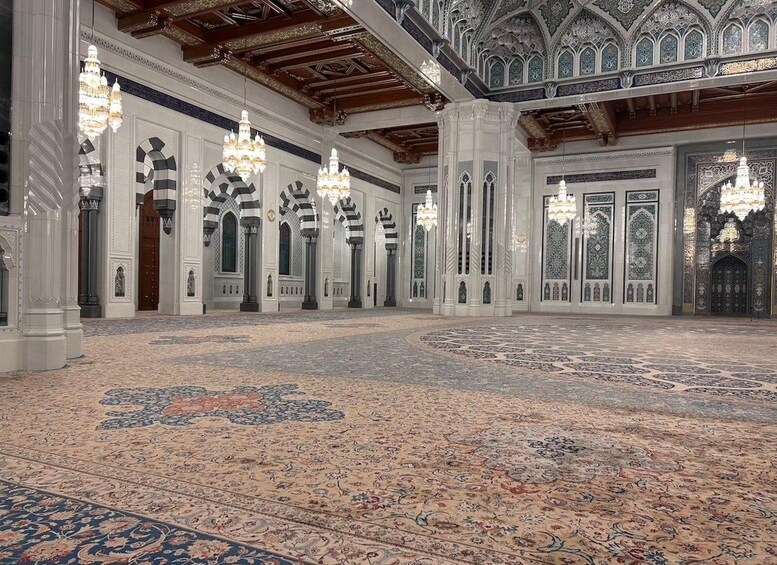 An ornate interior with intricate tile work, chandeliers, and a patterned carpet. 5