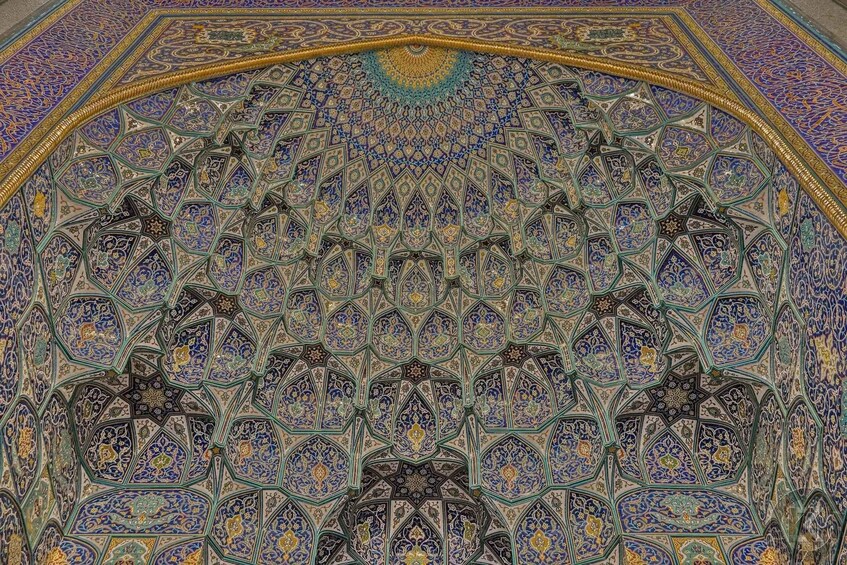 A detailed, ornate ceiling with intricate geometric patterns and Arabic calligraphy. 2