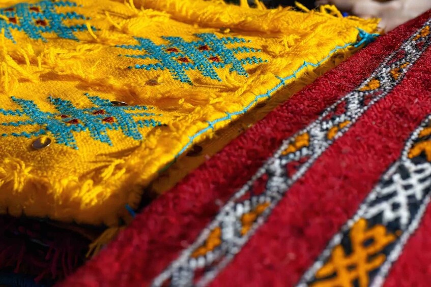 A close-up of a yellow fabric with blue embroidery. 2