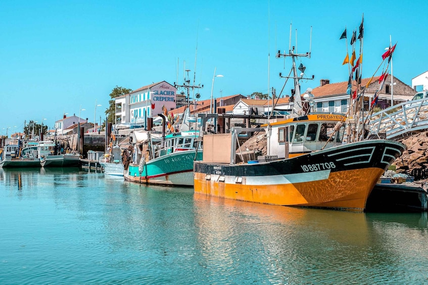 A harbor with boats docked, buildings, and a clear blue sky. 2