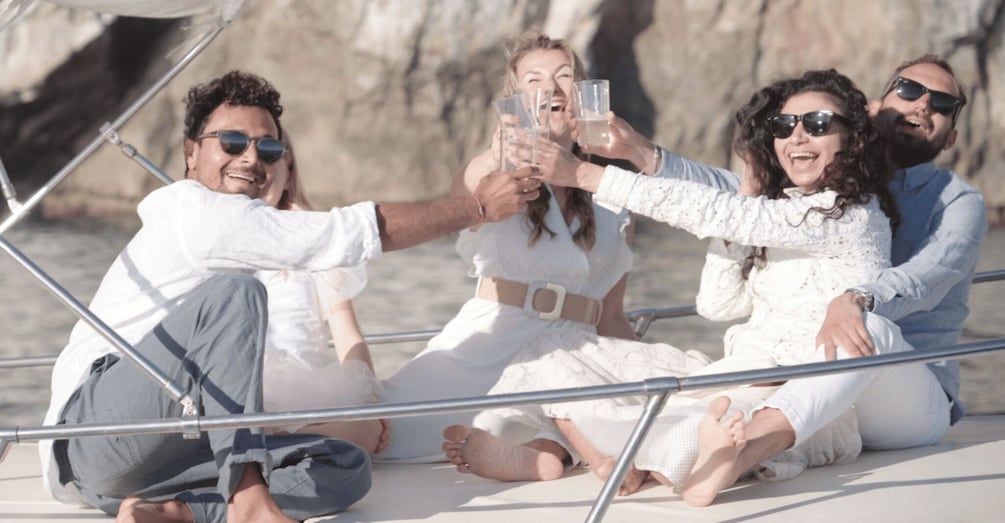 A group of people on a boat, toasting with glasses. 4