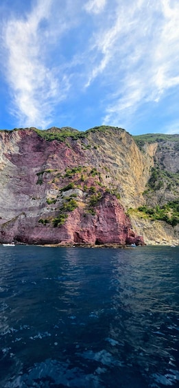 A coastal cliff with a boat in the water. 2