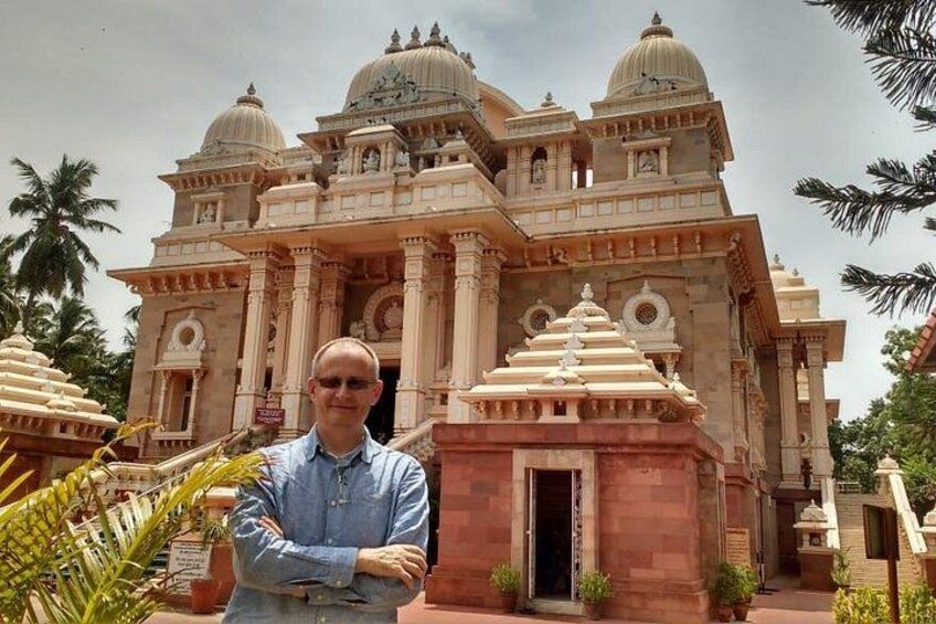A man standing in front of a large, ornate building with domes and intricate architecture. 3