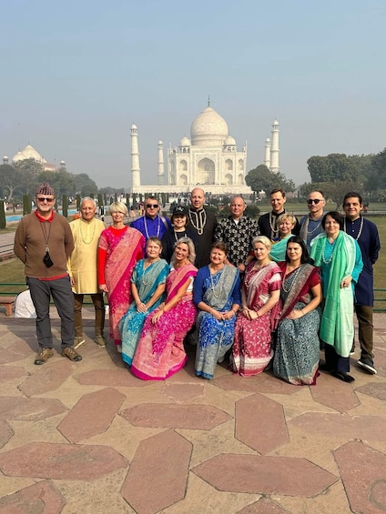 A group of people posing in front of the Taj Mahal. 2