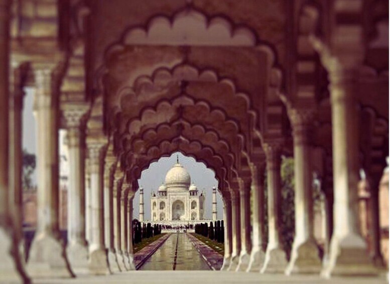 A corridor leading to the Taj Mahal with arches and columns. 1