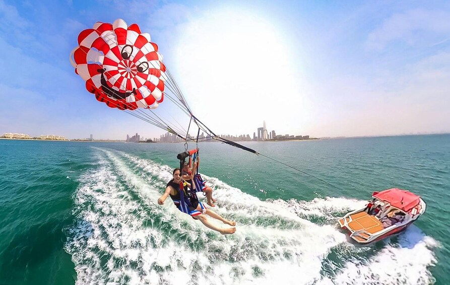 A parasailing activity with a city skyline in the background. 3