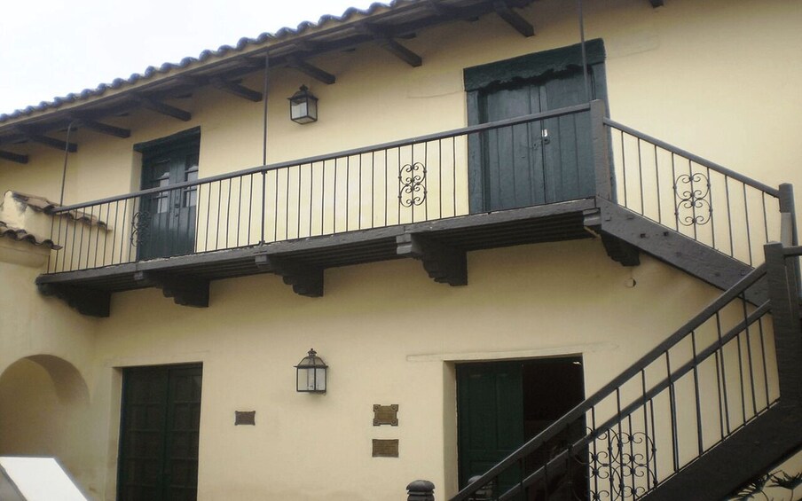 A building with a balcony, a staircase, and two lanterns. 2
