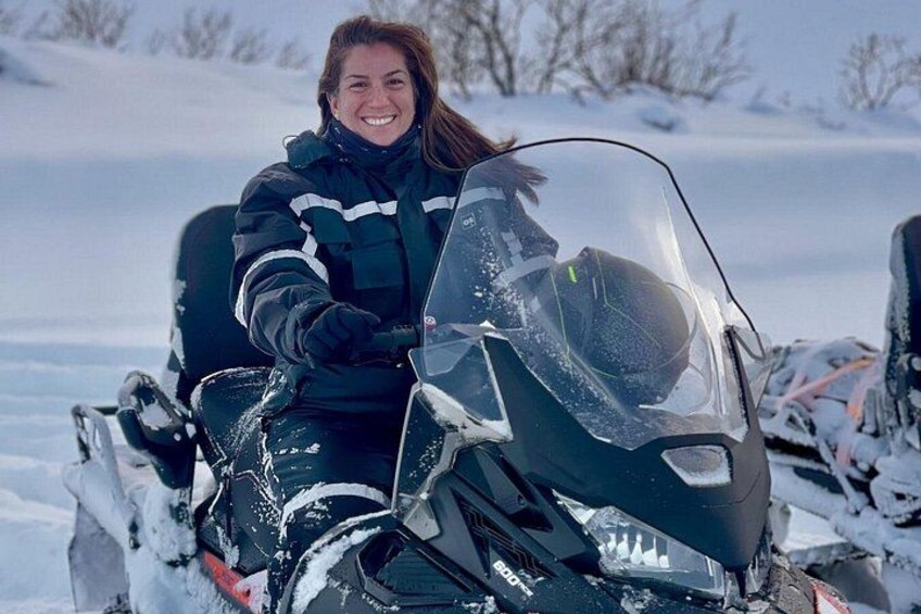 A person on a snowmobile in a snowy landscape. 1