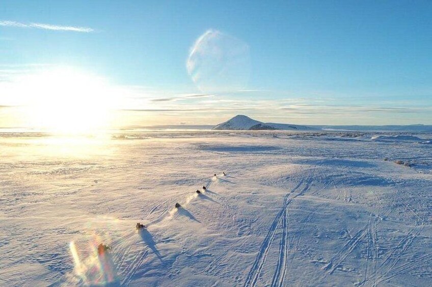 A snowy landscape with a mountain in the distance and a clear sky. 5