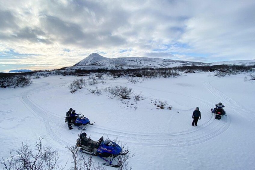 A snowy landscape with sleds and a person walking. 4