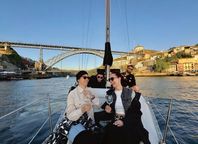 A group of people on a boat with a bridge and historic buildings in the background. 2