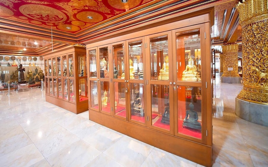 A temple interior with golden statues and intricate ceiling designs. 4