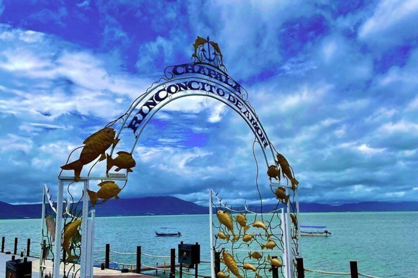 A metal archway with fish sculptures and the text 'CHARTERHOUSE OF THE ATLANTIS.' 2