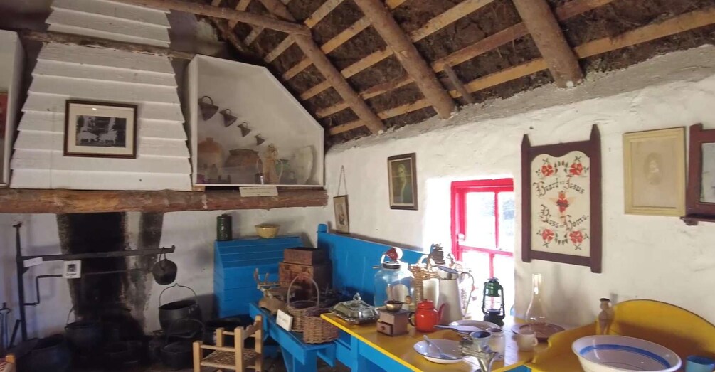A rustic kitchen with wooden beams, a stove, and various kitchen utensils. 3
