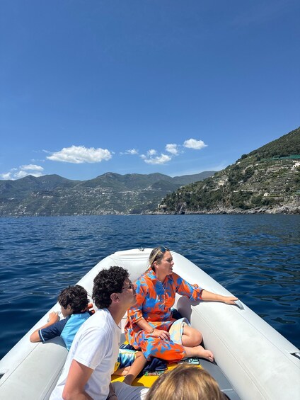 A family on a boat with a mountainous coastline in the background. 5