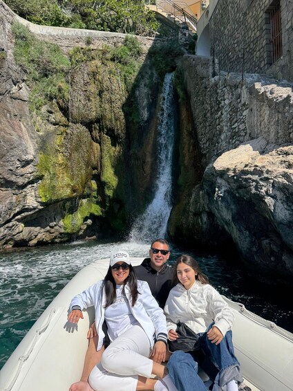 A group of people on a boat near a waterfall. 4