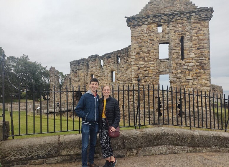 A historical stone structure with a black metal fence in front. 2