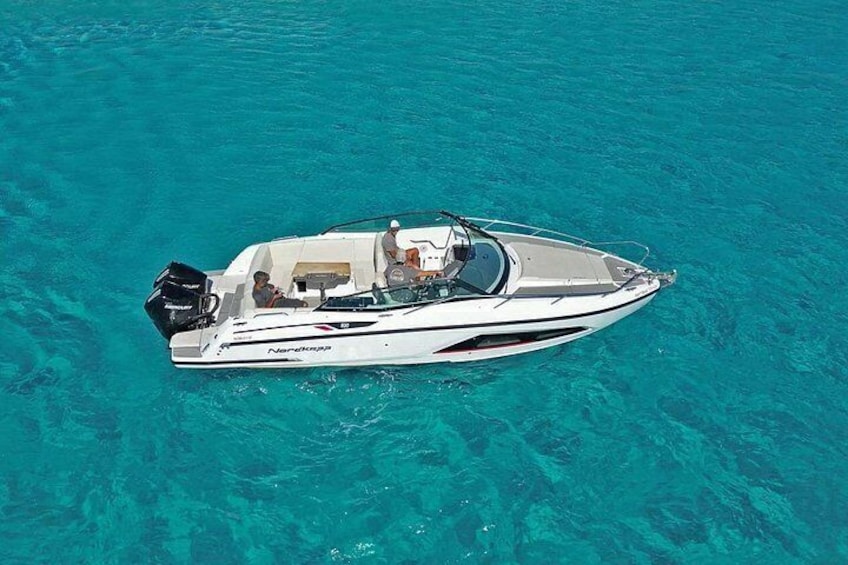 Un bateau à moteur blanc, baptisé « Nereyra », navigue sur une eau turquoise et limpide. 5