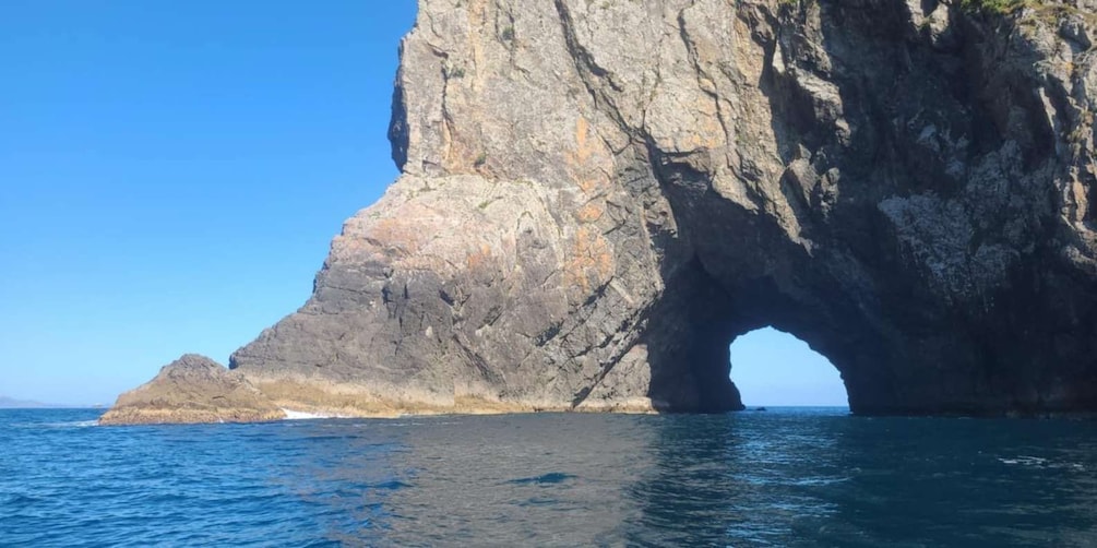 Une grande formation rocheuse surmontée d’une arche naturelle qui s’étend au-dessus de l’océan. 4