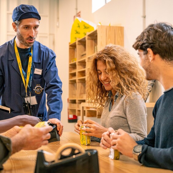 A group of people engaged in a hands-on activity at a table, possibly a workshop or educational session, with tools and materials on the table. 3