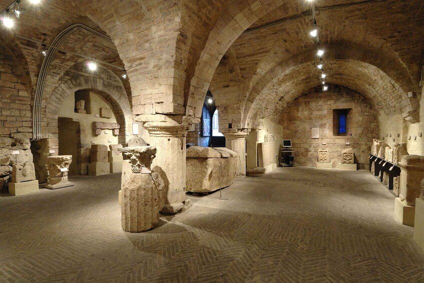 Un ancien bâtiment en pierre, doté de voûtes en arc et de colonnes. 1