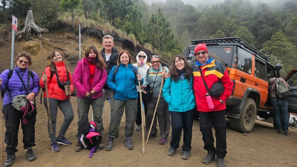 A group of hikers with a vehicle in a forested area. 5