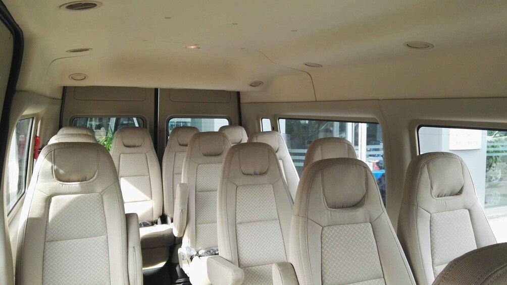 The interior of a vehicle with beige leather seats and a sunroof. 5