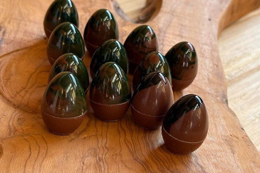 A wooden surface with several glossy, dark brown objects resembling eggs. 2
