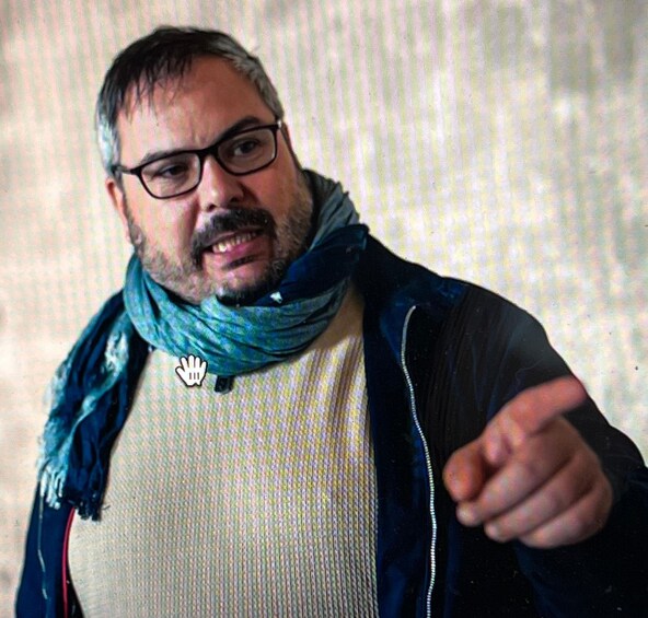 A person wearing a blue scarf and pointing. 3