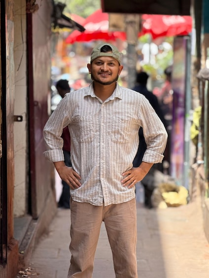 A person standing in a narrow street with shops on either side. 5