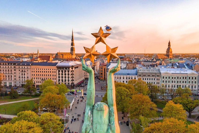 Une vue urbaine mettant en scène une sculpture imposante de mains tenant des étoiles, entourée de bâtiments historiques et se découpant sur un ciel dégagé. 1