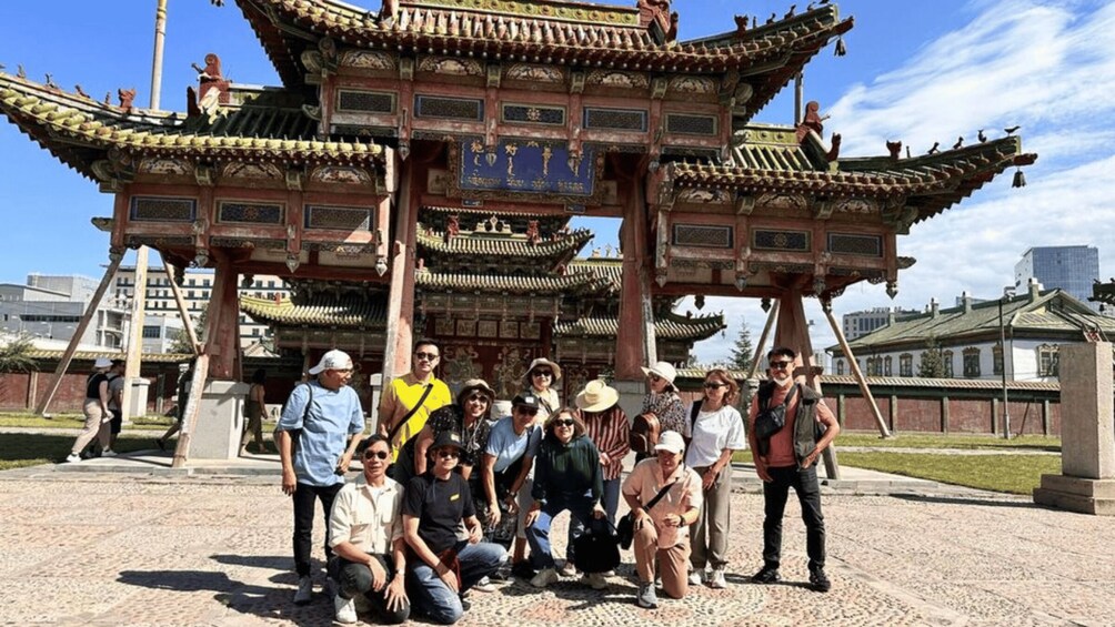 A group of people posing in front of a traditional Chinese pavilion with ornate roofs and intricate designs. 3