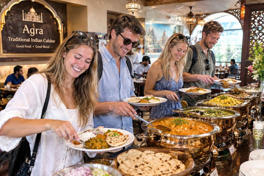 A buffet with various Indian dishes, a sign reading 'Agra Traditional Indian Cuisine,' and a mural of a cityscape. 2