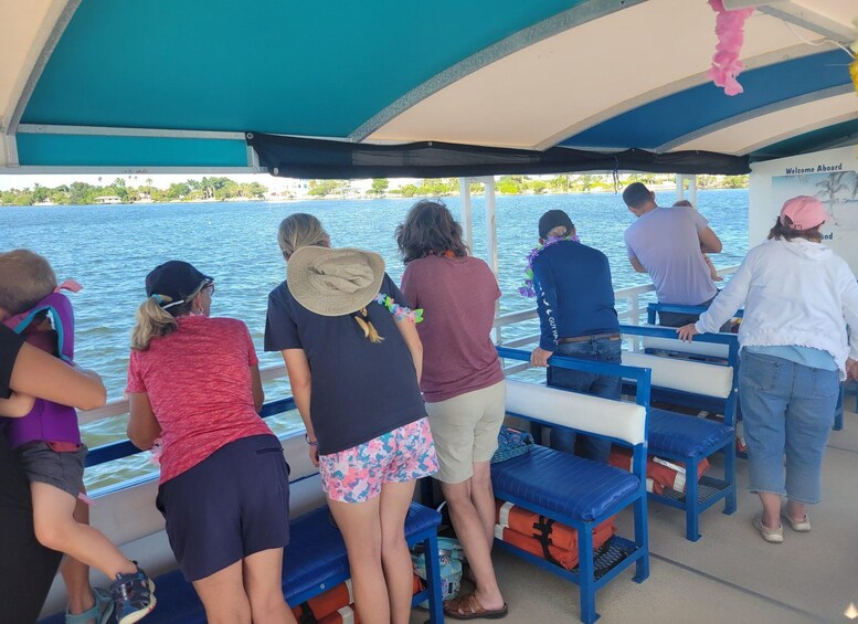 People on a boat with a view of the water and a beach in the background. 2