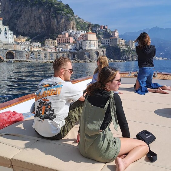 People on a boat with a coastal town in the background. 3
